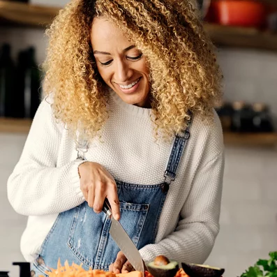 Hühnersuppe, Ingwer und Co. sind eine echte Wohltat bei einer Erkältung. Frau kocht Hühnersuppe bei einer Erkältung.